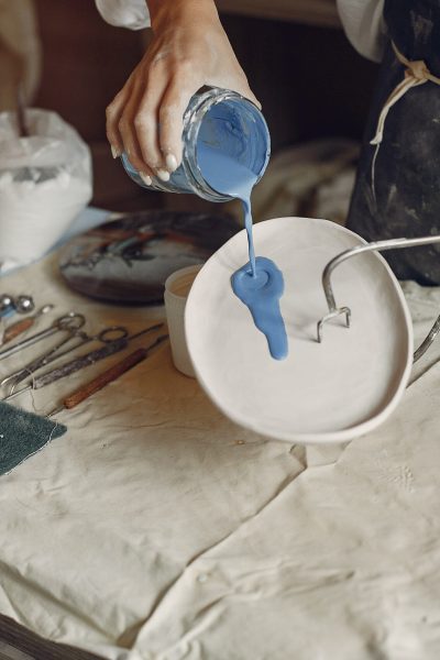 A young woman makes dishes in a pottery Woman in a pottery. Master make a dishes. Artist works with a clay